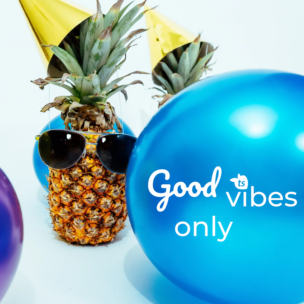 Pineapple with sunglasses and party hats surrounded by balloons. Good Vibes Only.