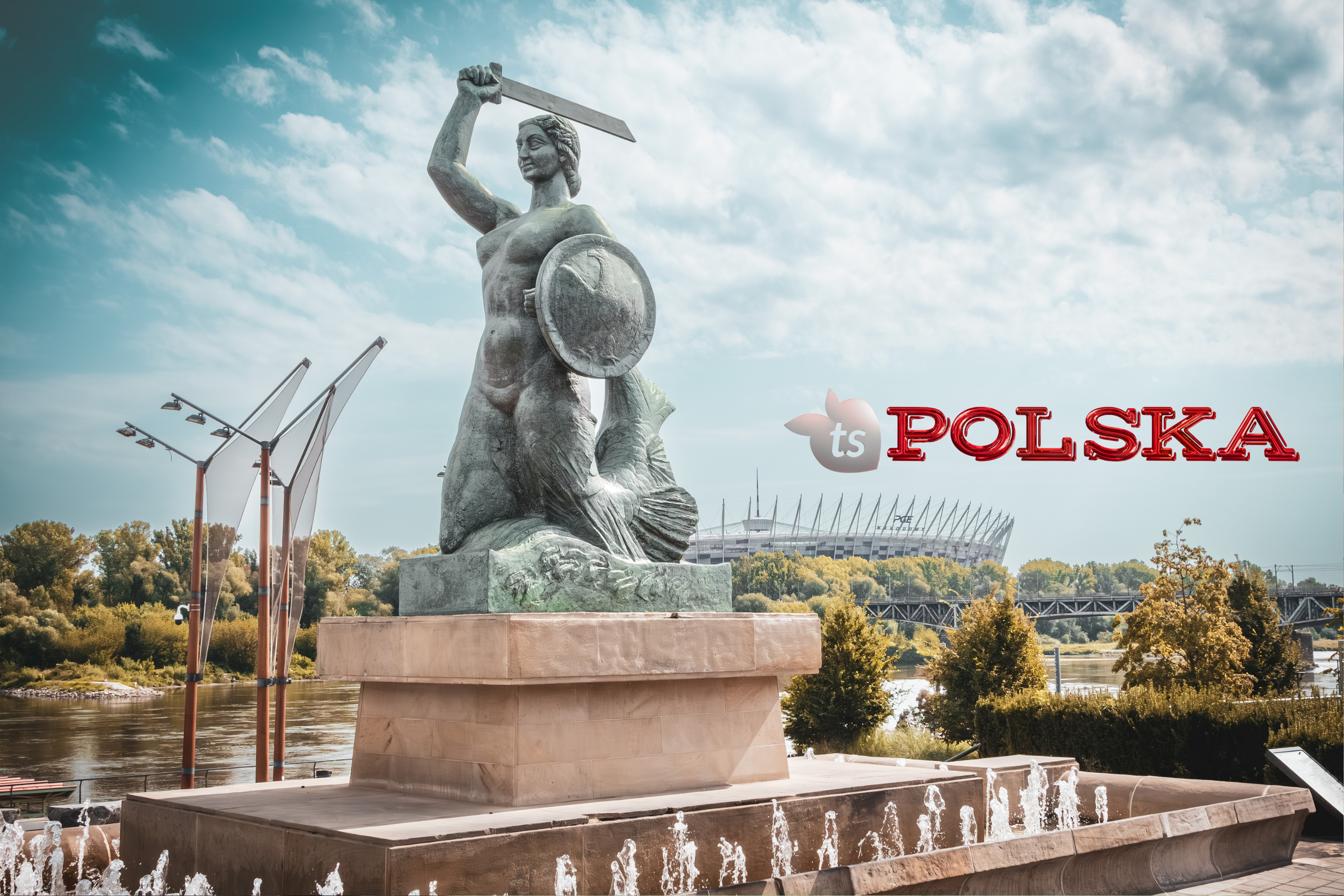 Statue with a sword and shield in a park setting with 'Polska' branding.