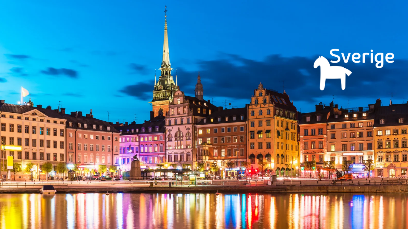 Downtown Stockholm at night with colorful buildings and a reflection on the water, featuring the word 'Sverige' and a swedish flag icon.